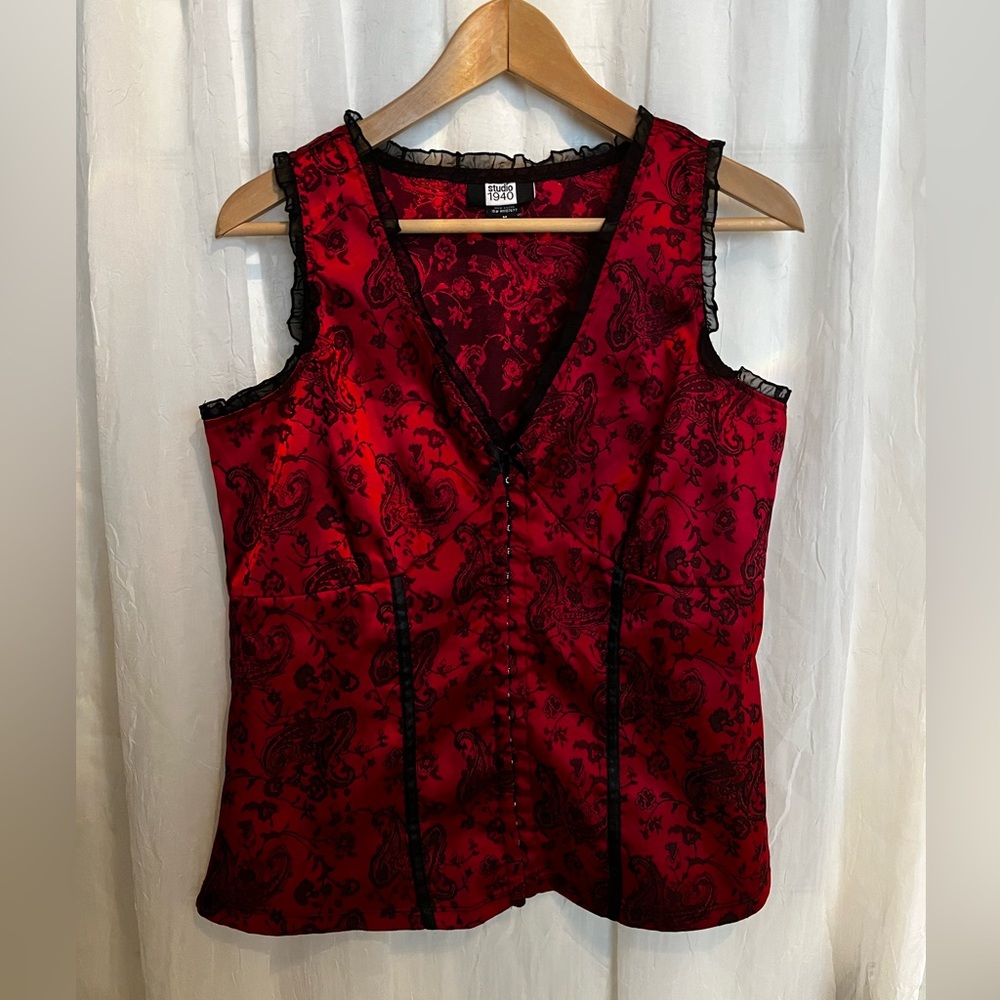 Red and black elegant top with frilly details around the collar and shoulders.